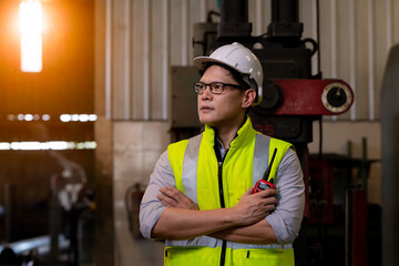 Portrait engineer industry posing under work and inspection in site wearing causal uniform, standing on control operating work station in industry.