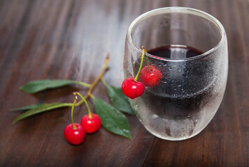 cherry juice.cherry wine a steamed glass on the table with ripe cherry berries