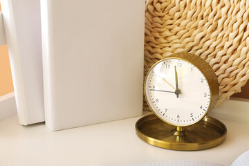 Alarm clock and books on table, closeup