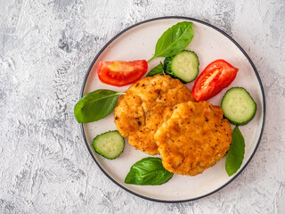 Chicken cutlets with vegetables, cucumber and tomatoes and basil