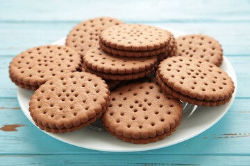 Chocolate chip cookie on white plate on blue wooden background. Top view.