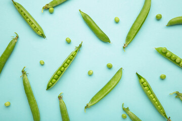 Fresh green peas on blue background. Flat lay