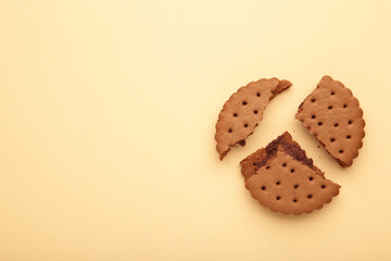 Chocolate chip cookie broken on beige background.Top view.