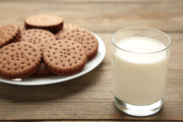 Chocolate chip cookie and glass of milk on grey wooden background. Top view.