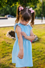 The child is bitten by mosquitoes. A girl combs insect bites on her hands. Redness on the skin and...