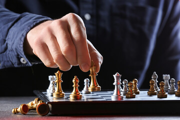 Man playing chess on dark background, closeup