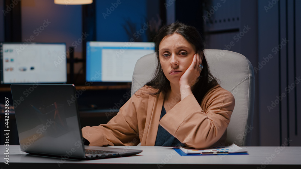 Poster portrait of exhausted workaholic manager checking economic statistics using laptop computer while si