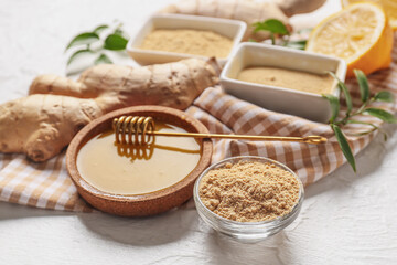 Bowls with ginger powder and honey on white background