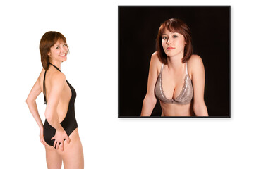 Rear view of a beautiful young woman wearing a black bathing suit in front of a lingerie photo of herself, isolated on white studio background