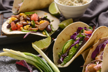 Tacos and tasty guacamole in bowl on table, closeup
