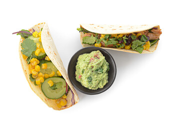 Tacos and tasty guacamole in bowl on white background