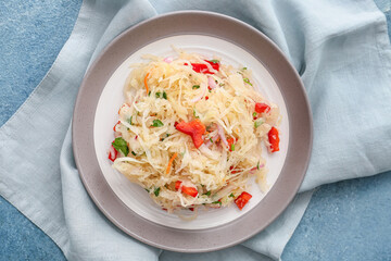 Plate with tasty sauerkraut on color background