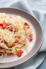 Plate with tasty sauerkraut on color background