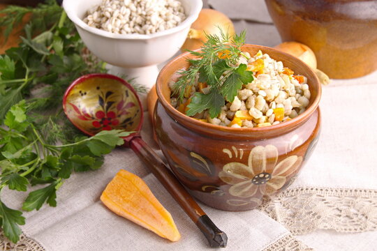 Pearl porridge with vegetables in a clay pot traditional Russian food languishing in the oven