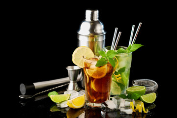 Glass of Fresh Long Island Ice Tea and Mojito Cocktail - studio shot on black background