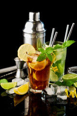 Glass of Fresh Long Island Ice Tea and Mojito Cocktail - studio shot on black background