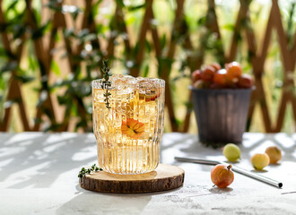 Summer gooseberry ice tea with thymes. Homemade non-alcoholic mocktail or lemonade with ripe...