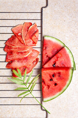 Winter supplies: slices of dried watermelon with fresh pieces on light background with grid