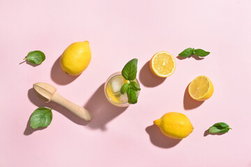 Glass of tasty lemonade with basil on color background