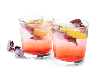 Glasses of tasty lemonade with basil on white background