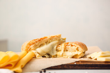 Tasty sandwiches with cheese on light background