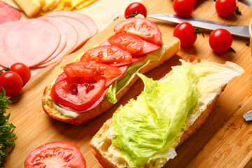 Preparing of tasty sandwiches on table, closeup