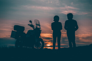 Fototapeta na wymiar Silhouette of lover couple in sunset with motorcycle in sunset.