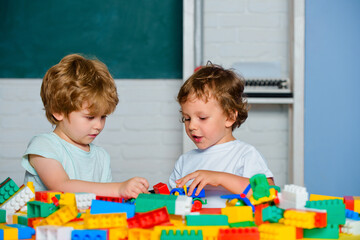 Boy Pupils from elementary school. Toddler kids play with blocks, trains and cars. Educational toys for preschool and kindergarten child.