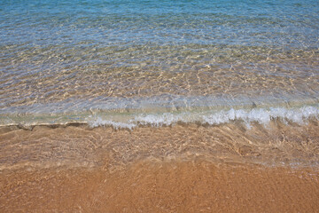 Beach with golden sand, turquoise ocean water. Panoramic sea view. Natural background for summer vacation.