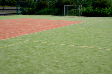 multifunctional outdoor playground for ball games at school. green artificial turf from a plastic...
