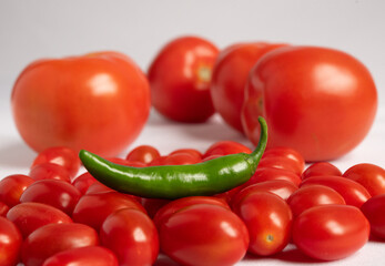 Chile verde con jitomates sobre fondo blanco 