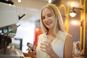 Close-up of Beautiful woman using coffee machine in kitchen