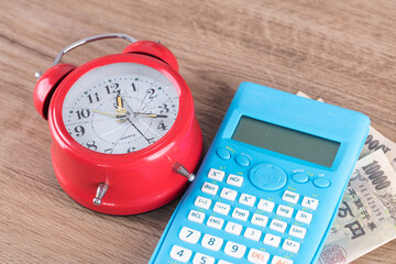 Alarm clock and calculator with broken dial and Japanese yen banknotes