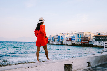 Mykonos Greece, Young woman in dress at the Streets of old town Mikonos during a vacation in...