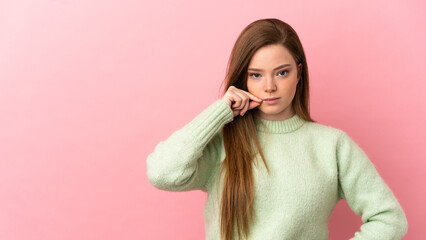 Teenager girl over isolated pink background showing a sign of silence gesture