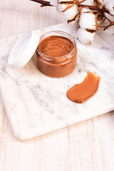 Natural skin care face clay mask on marble background.