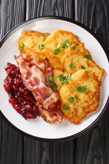 Raggmunk Crispy Swedish Potato Pancake with lingonberry jam and bacon close-up in a plate on the...