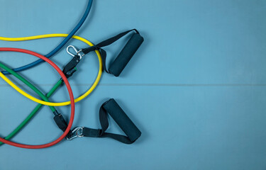 Colorful elastic resistance bands on a blue fitness mat