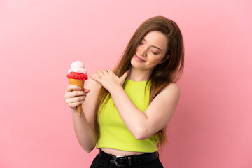 Teenager girl with a cornet ice cream over isolated pink background suffering from pain in shoulder for having made an effort