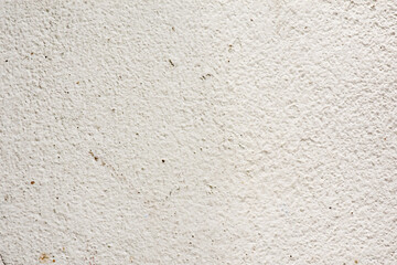 Rough surface of a concrete wall painted in greyish white, concrete wall background, blurred white background.