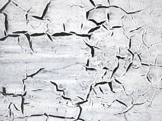 Obraz premium The texture of the painted white wall is covered with large black cracks. Concept background, texture