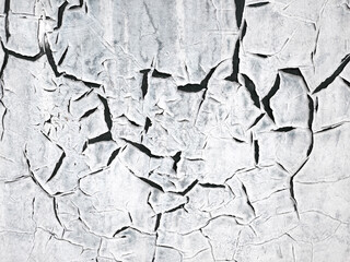 The texture of the painted white wall is covered with large black cracks. Concept background, texture