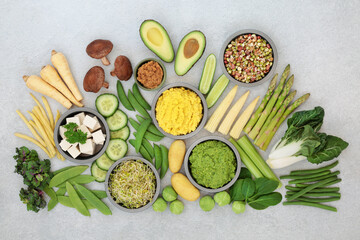 Vegan food for ethical eating concept with plant based health foods high in antioxidants, anthocyanins, fibre, vitamins, minerals, lycopene & smart carbs. Flat lay on rustic wood.