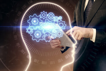 Double exposure of man's hand holding and using a digital device and brain hologram drawing. Data concept.