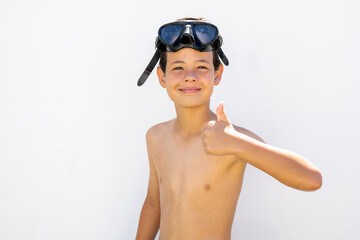 Little swimmer boy isolated in white with thumb up.
