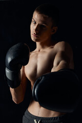 athlete in boxing gloves on black background portrait cropped view model close-up