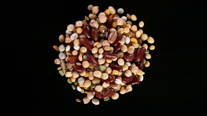 Rotating Raw Various Legumes on Black Background. Top Shot.