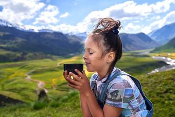 funny beautiful girl holds a mug and drinks tea in the mountains