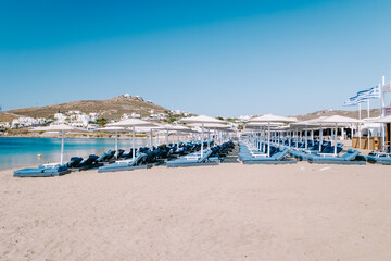 Ornos beach Mykonos island, famous Ornos beach organized with sun beds emerald clear water beach of...