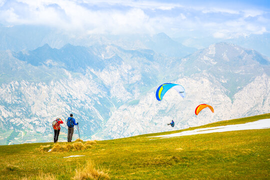 Gleitschirmfliegen am Gardasee mit Bergpanorama im Hintergrund See Paragleiter Italien Sport Berg / Paragliding at Garda lake in Italy Mountains Alps Paragliter